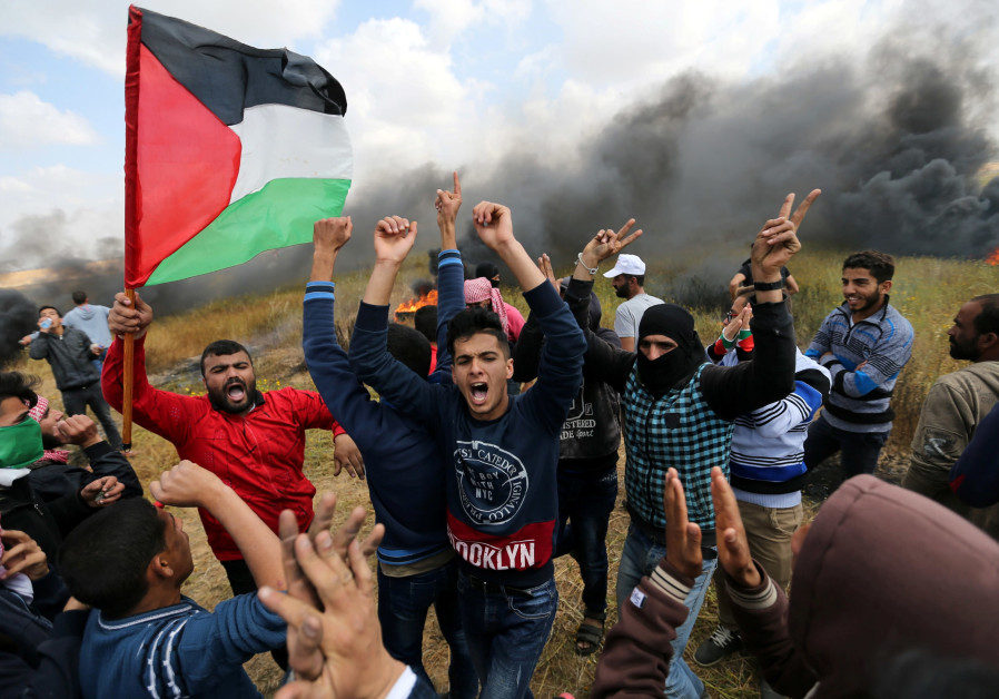 Palestinian protestors shout during clashes with the IDF ( IBRAHEEM ABU MUSTAFA / REUTERS).