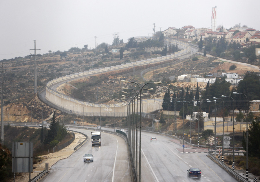 Vehicles drive on Highway 443 past the West Bank Jewish settlement of Beit Horon