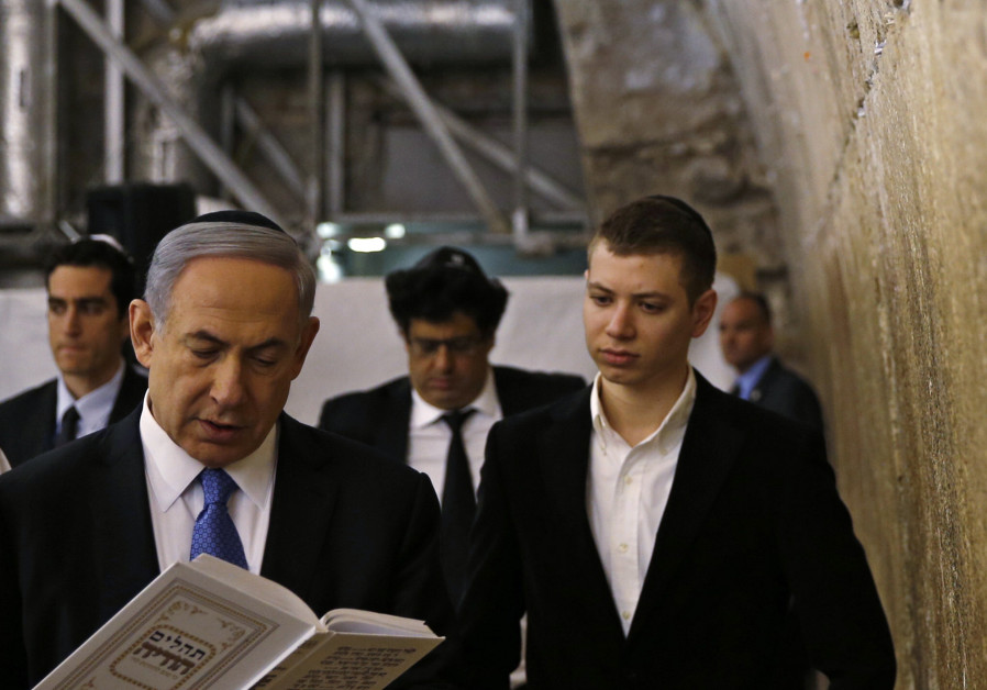 Yair Netanyahu observes his father Israeli Prime Minister Benjamin Netanyahu reading a prayer at the
