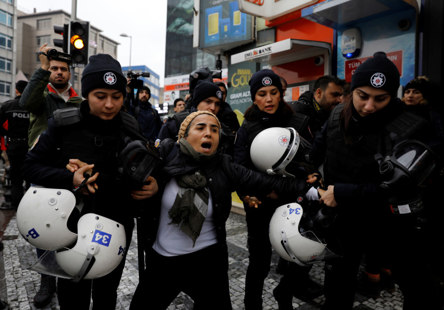 Riot police detain a demonstrator during a protest against Turkey's operation in Syria's Afrin
