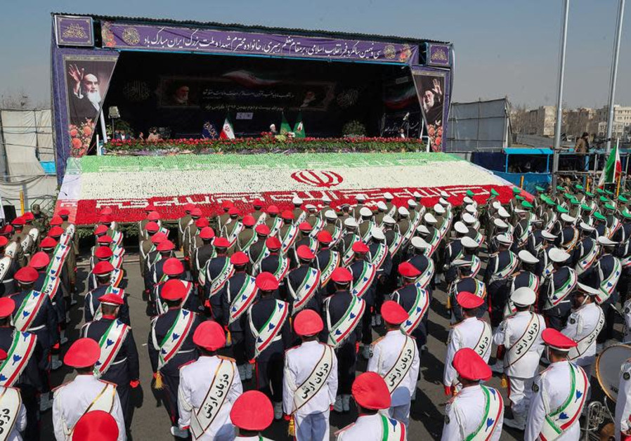 Iranian President Hassan Rouhani gestures as members of Iranian armed forces take part in a rally ma