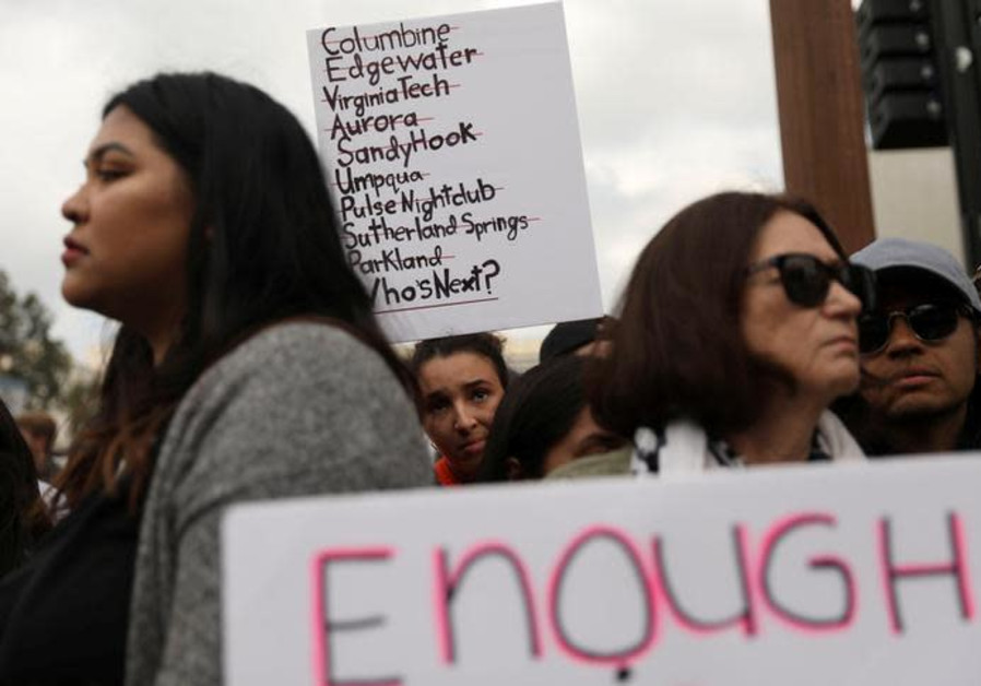 An attendee holds a sign with a list of school shootings during "March for Our Lives"