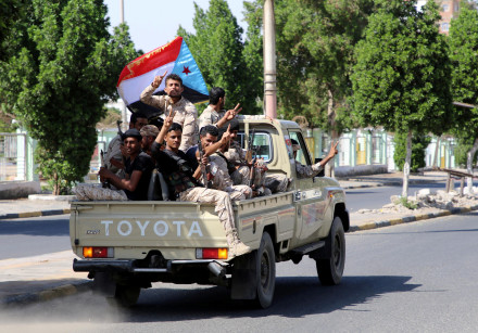 Southern Yemeni separatist fighters flash the V sign as they ride on the back of a truck in Aden
