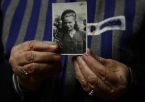 Auschwitz death camp survivor Jadwiga Bogucka holds a picture of herself from 1944 in Warsaw