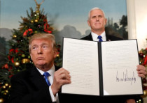 U.S. Vice President Mike Pence stands behind as U.S. President Donald Trump holds up the proclamatio