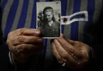 Auschwitz death camp survivor Jadwiga Bogucka holds a picture of herself from 1944 in Warsaw
