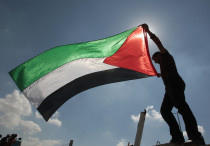 A Palestinian holds a flag during a protest