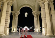 Saudi men walk at the entrance to the Ritz-Carlton Hotel.