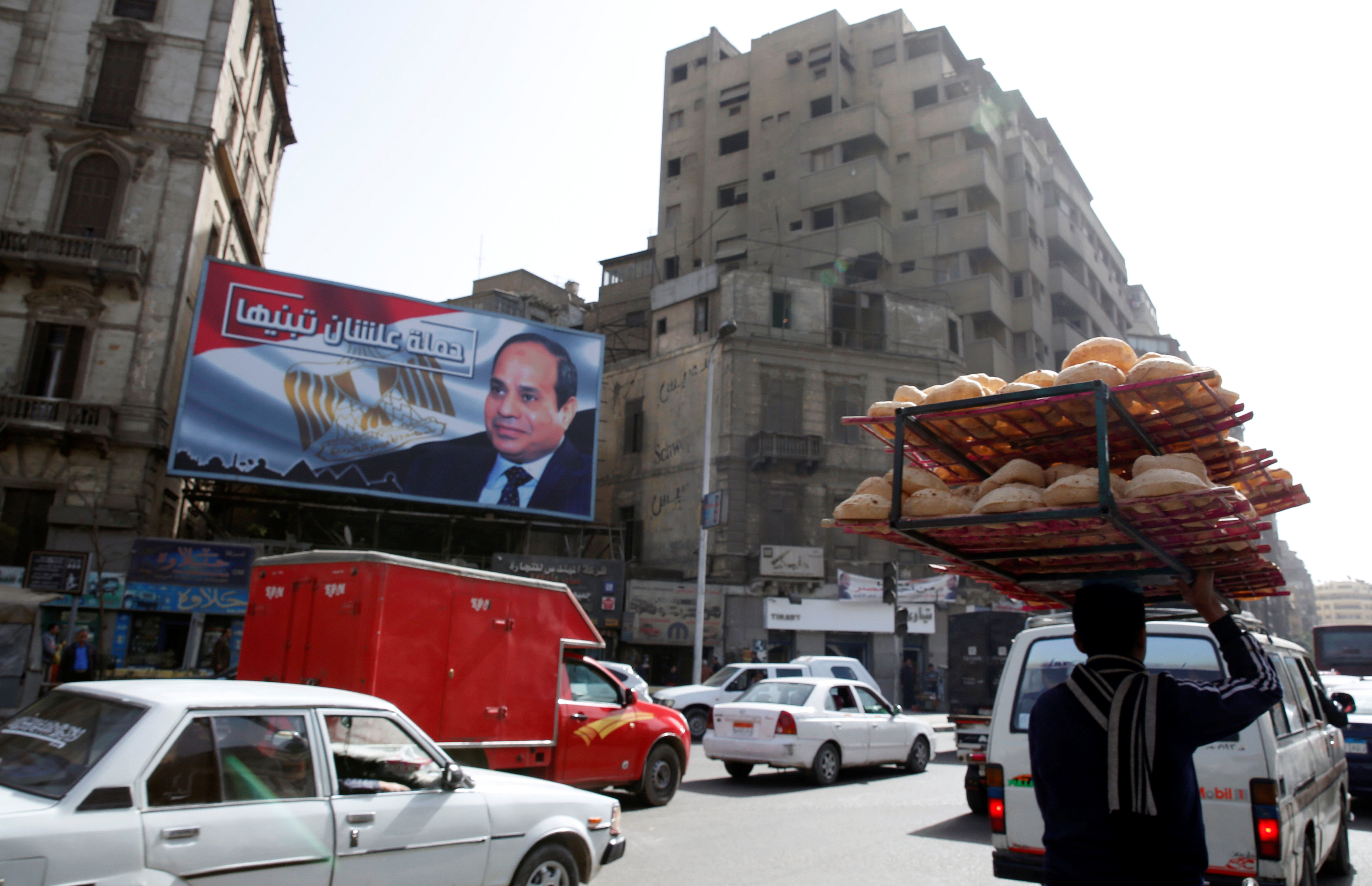 A busy street near a poster of Egypt's President Abdel Fattah al-Sisi for the upcoming presidential election in Cairo, Egypt, January 22, 2018 (Reuters)
