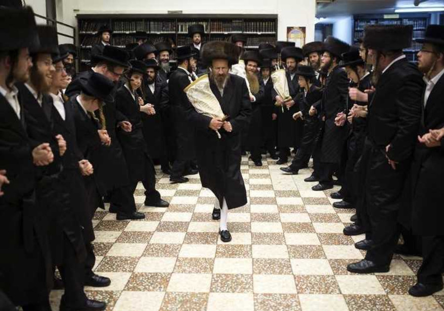 Ultra-Orthodox Jews dance with Torah scrolls during the celebrations of Simchat Torah in a synagogue