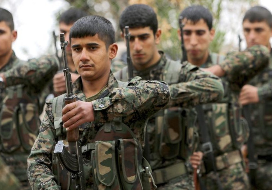 Fighters of the Kurdish People's Protection Units (YPG) carry their weapons at a military training