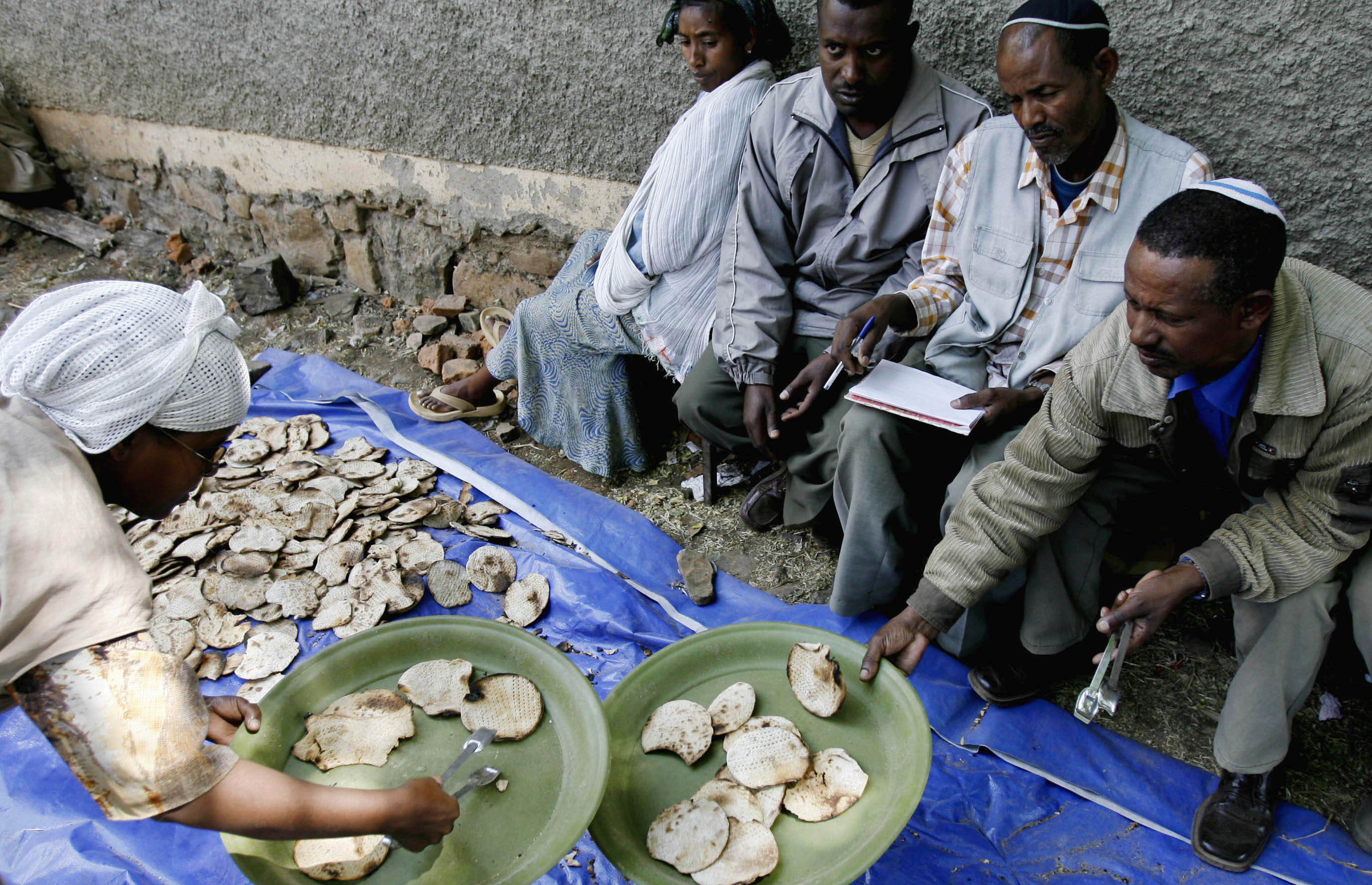 An Jewish Ethiopian woman gives matzahto a man ahead of Passover at a compound while awaiting immigration to Israel in Gondar March 9, 2007 (ELIANA APONTE/REUTERS).