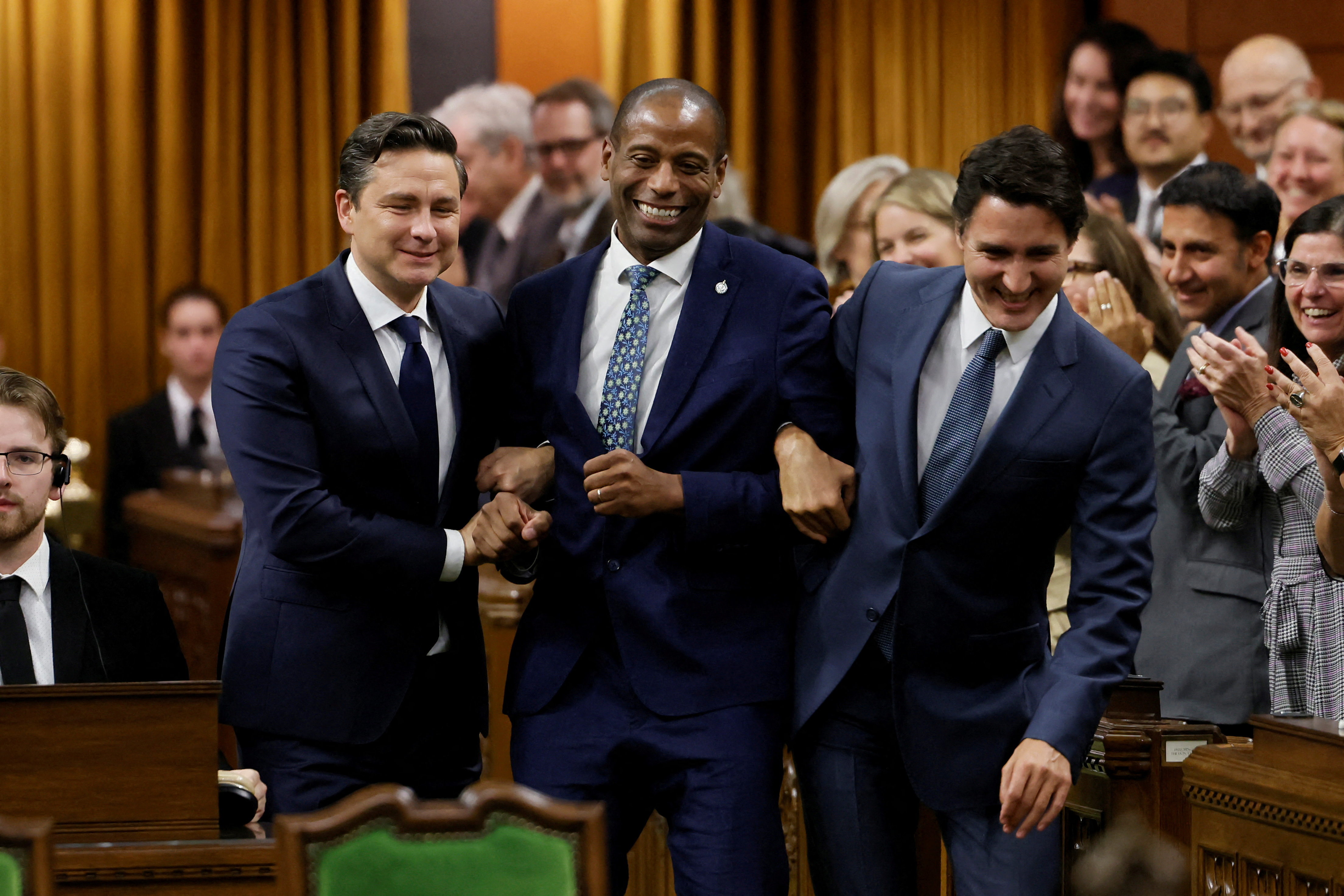  Newly elected Speaker Greg Fergus pretends to resist while being walked through the House of Commons by Canada's Prime Minister Justin Trudeau and Conservative Party of Canada leader Pierre Poilievre on Parliament Hill in Ottawa, Ontario, Canada October 3, 2023 (Reuters/Blair Gable)