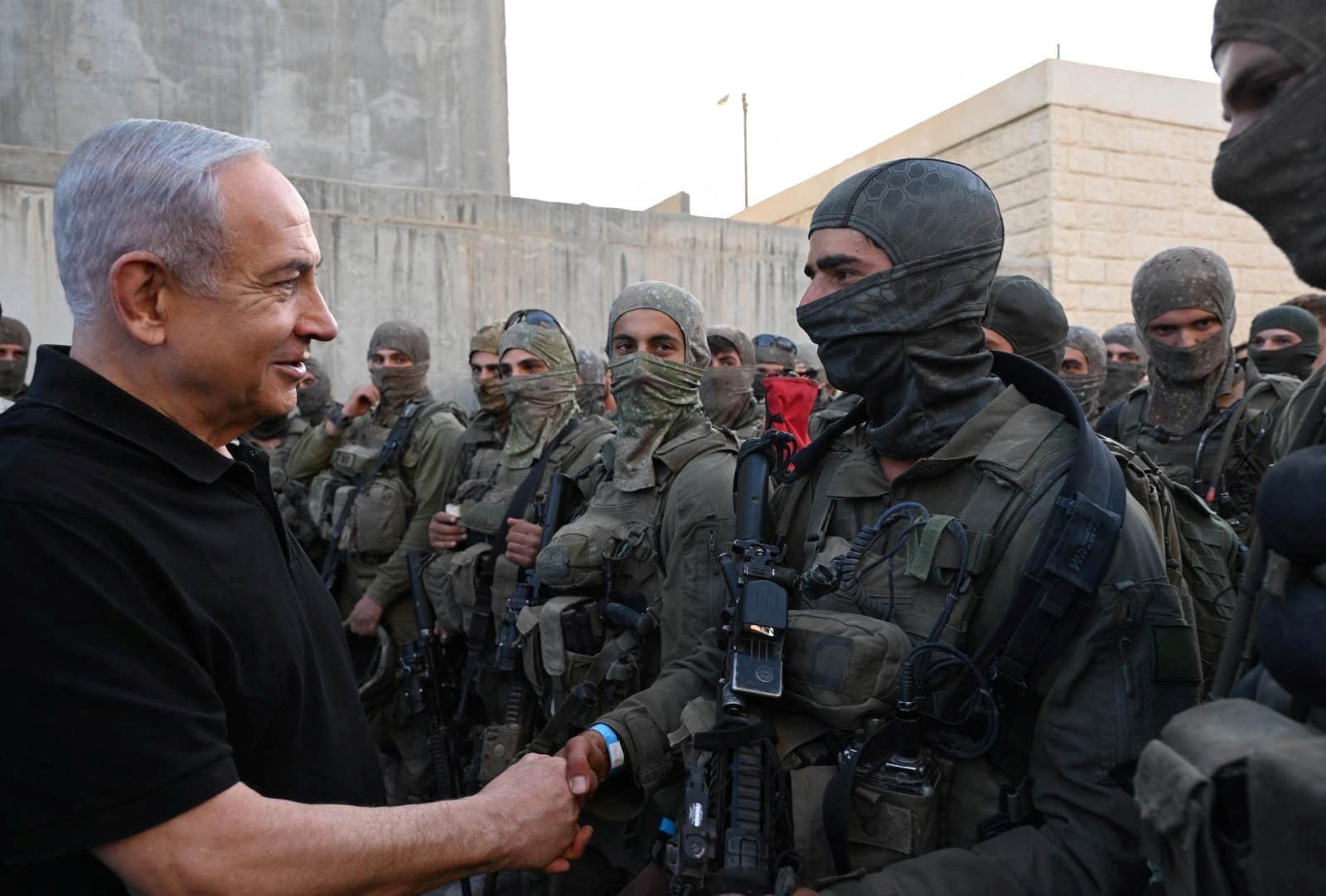 Israeli Prime Minister Benjamin Netanyahu greets a soldier as he visits an Israeli army base in Tze'elim, Israel November 7, 2023. Israeli Government Press Office/Haim Zach/Handout via REUTERS