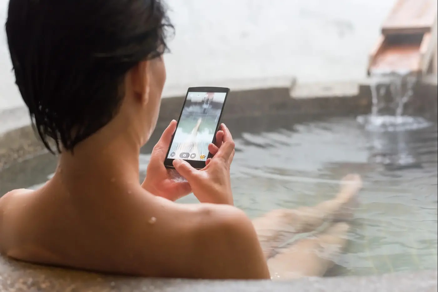 Bath with cellphone (Credit: Shutterstock)