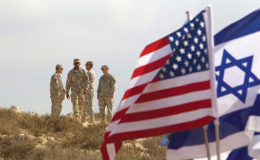 US SOLDIERS stand in the background next to Israeli and American flags during an exercise in Israel.
