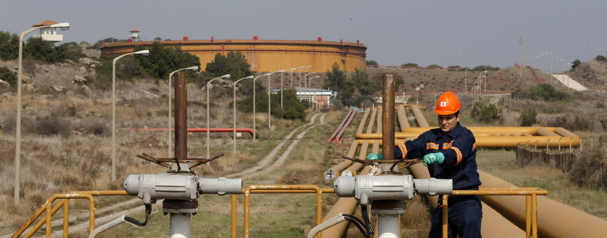 A worker checks the valve gears of pipes linked to oil tanks at Turkey's Mediterranean port of Ceyhan, which is run by state-owned Petroleum Pipeline Corporation (BOTAS), some 70 km (43.5 miles) from Adana February 19, 2014
