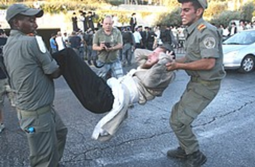 Police remove haredi protesters trying to block tr (photo credit: Ariel Jerozolimski)