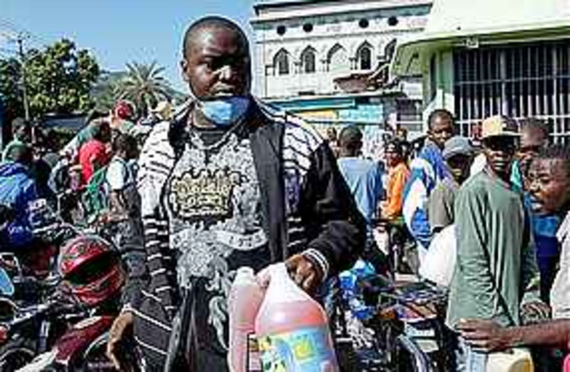 A man holds two bottle of fuel in Haiti, Thursday (photo credit: AP)