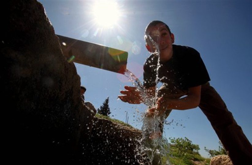 A boy washes himself in Jordan (photo credit: AP)