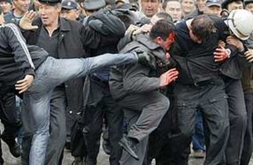 Kyrgyz protester kicks 311 (photo credit: Associated Press)