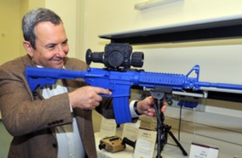 Barak shooting blue gun smiling 311 (photo credit: Ariel Harmoni/ Defense Ministry)