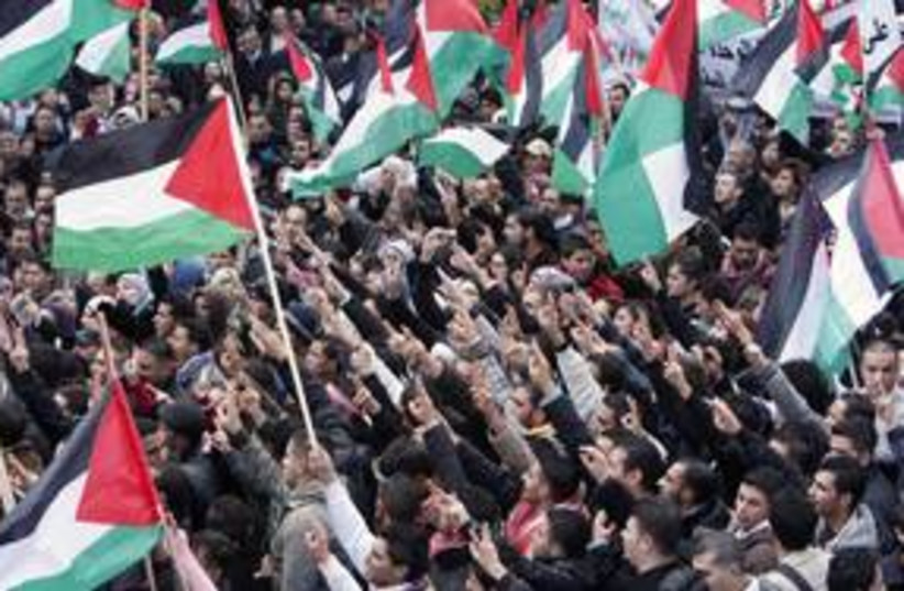 Palestinians wave flags during a protest  (R) 311 (photo credit: Reuters)