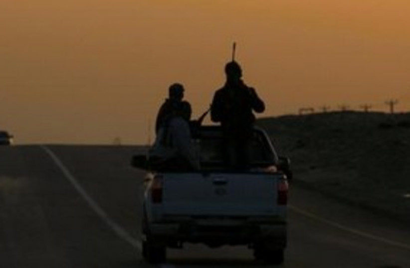 Rebel fighters drive towards Ras Lanuf, Libya 311 (R) (photo credit: REUTERS/Andrew Winning)