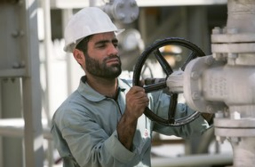 An Iranian oil worker 311 (R) (photo credit: REUTERS/Morteza Nikoubazl)