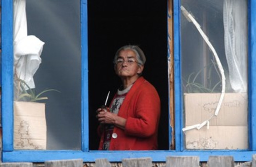 Elderly woman looks out of window [illustrative] (photo credit: Ivan Alvarado / Reuters)