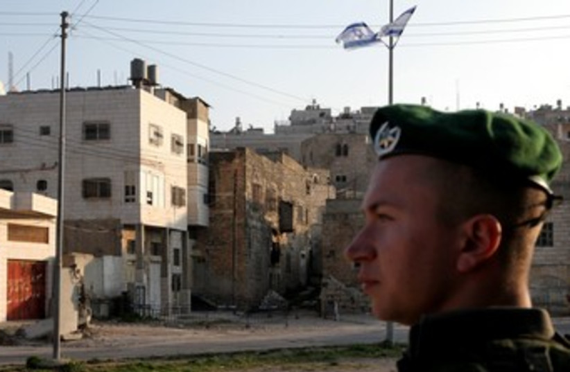 IDF soldier stands guard near Beit Hamachpela_370 (photo credit: Marc Israel Sellem/The Jerusalem Post)