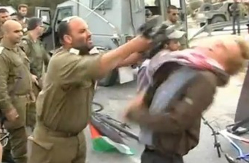 IDF officer hitting activist with M-16 370 (photo credit: YouTube Screenshot)