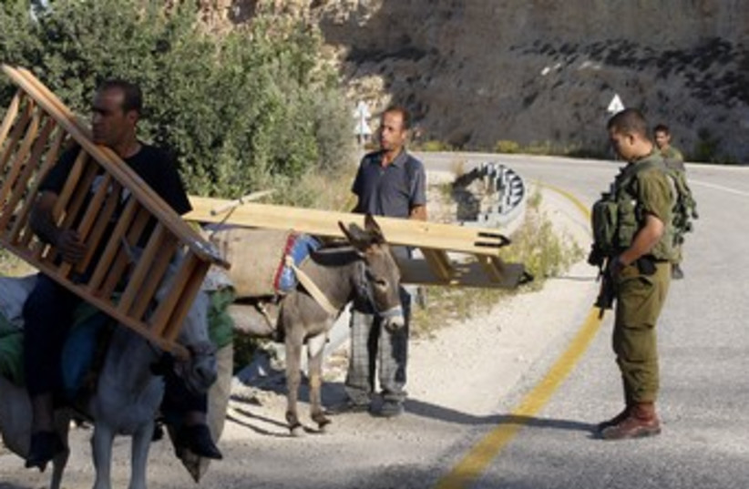 Palestinians return from olive harvest, idf guards 370 (photo credit: Reuters/Abed Omar Qusini)