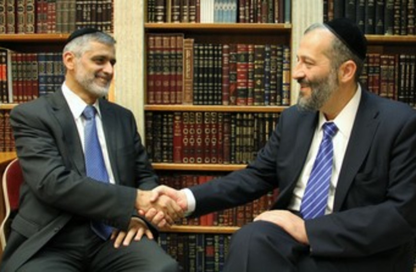 Shas's Arye Deri, Eli Yishai shake hands 370 (photo credit: Shas handout)