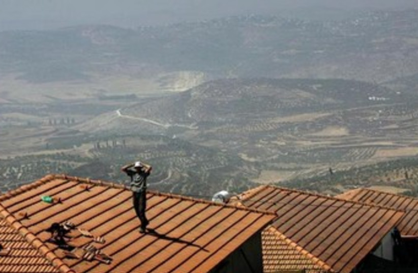 jewish settlers stands on a house Homesh in 2005 370 (photo credit: REUTERS)