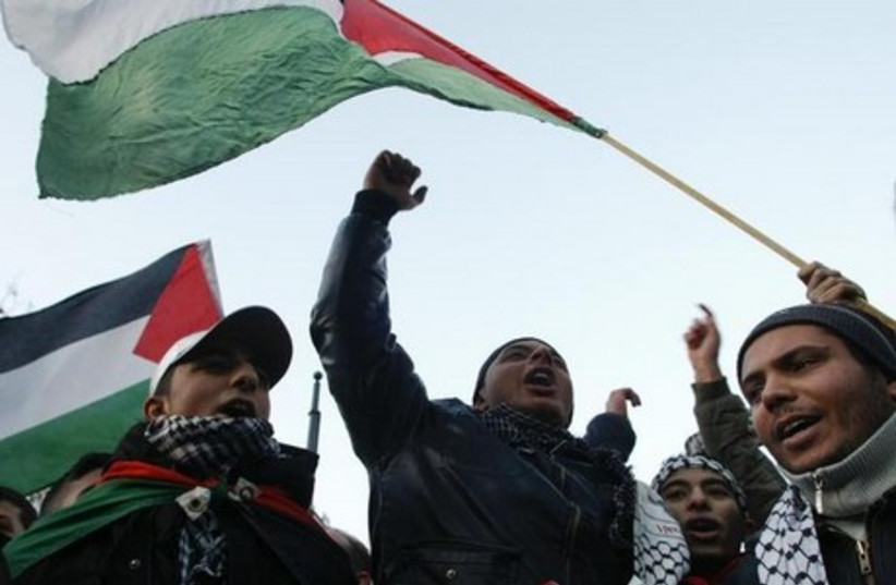 Protestors wave with Palestinian flags and shout slogans during a demonstration in Berlin (photo credit: REUTERS)