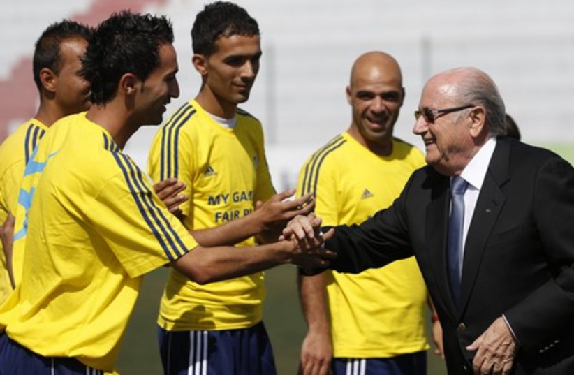 FIFA President Sepp Blatter (R) shakes hands with Palestinian coaches (photo credit: REUTERS)
