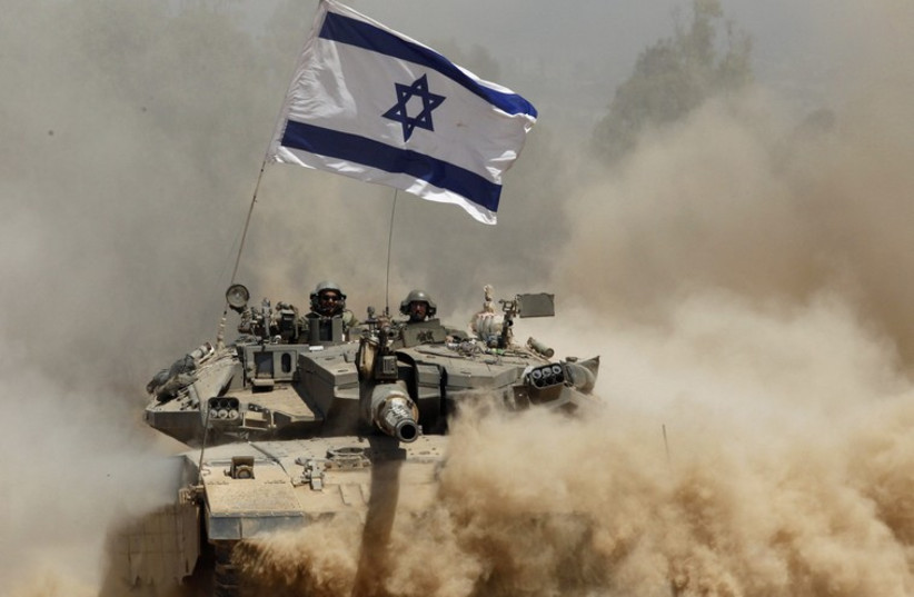 Israeli soldiers ride a tank after returning to Israel from Gaza (photo credit: REUTERS)