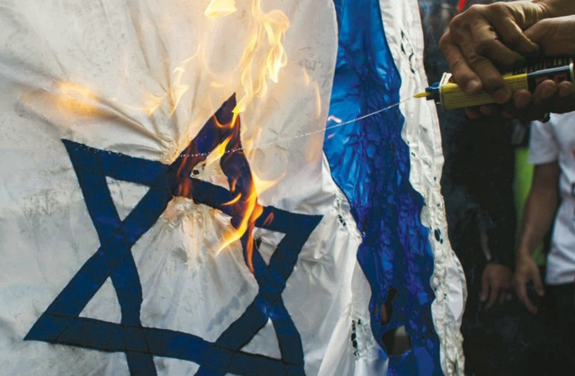 Demonstrators burn an Israeli flag in front of the Israeli Embassy in Bangkok (photo credit: REUTERS)