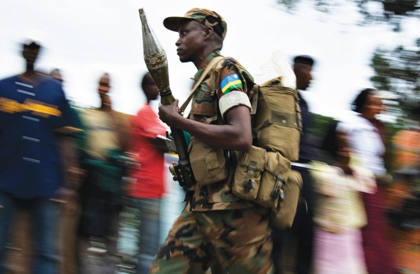 A RWANDAN soldier runs with his unit during a training mission. (photo credit: REUTERS)