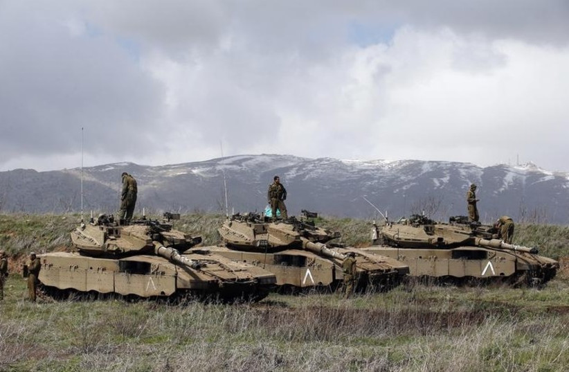 IDF soldiers stand atop tanks in the Golan Heights near Israel's border with Syria. (photo credit: REUTERS)