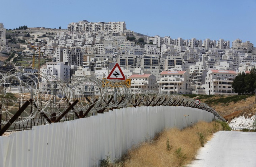 A section of the controversial Israeli barrier is seen close to a Jewish settlement near Jerusalem  (photo credit: REUTERS)