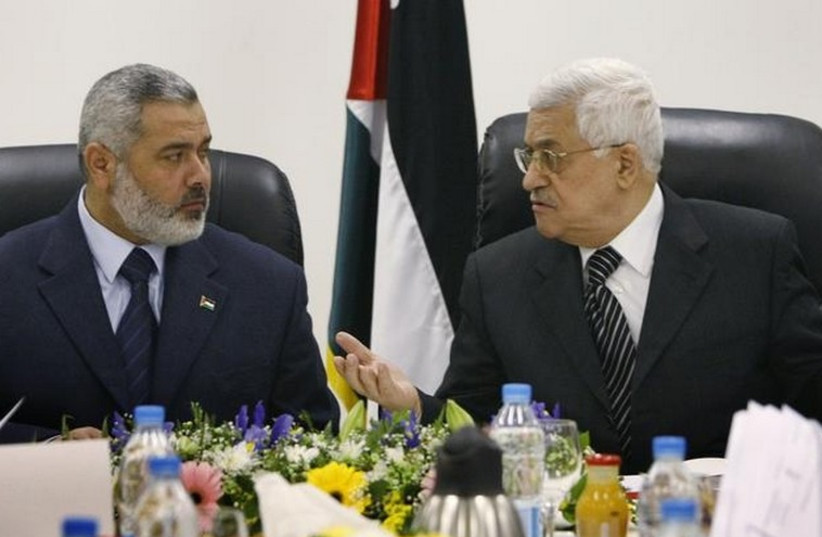 Palestinian Authority President Mahmoud Abbas (R) talks with Hamas leader Ismail Haniyeh. (photo credit: REUTERS)