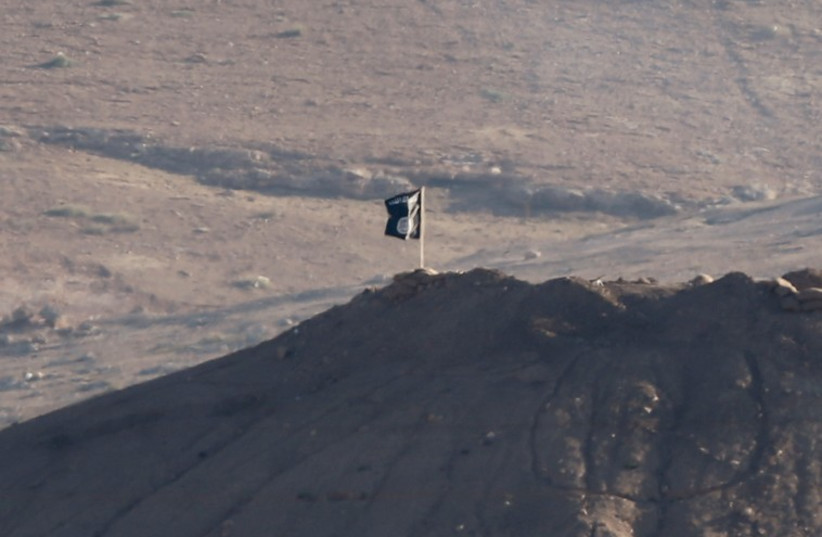 A black flag belonging to the Islamic State is seen near the Syrian town of Kobani, as pictured from the Turkish-Syrian border (photo credit: REUTERS)