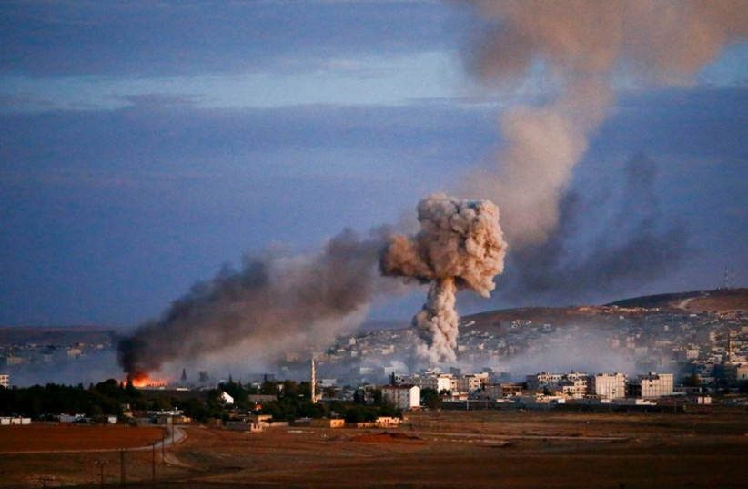 Smoke and flames rise over the Syrian border town of Kobani after an airstrike, October 20, 2014 (photo credit: REUTERS)