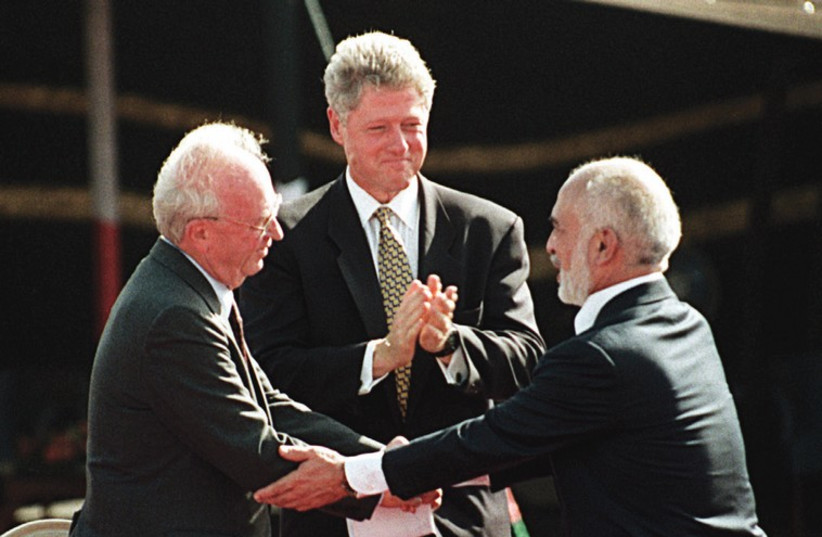 US PRESIDENT Bill Clinton applauds as prime minister Yitzhak Rabin and Jordanian King Hussein shake hands after signing a peace treaty between the countries in the Arava 20 years ago (photo credit: REUTERS)