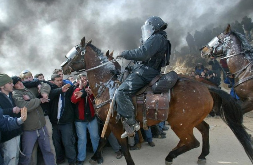 Mounted Israeli police scuffle with pro-settler supporters at the Amona outpost, February 1, 2006 (photo credit: REUTERS)