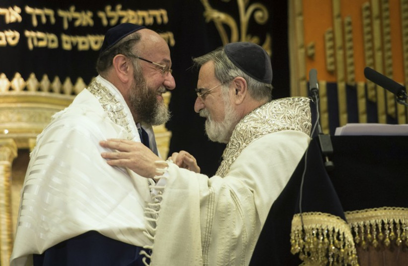 Former chief rabbi, Jonathan Sacks (R), congratulates the new chief rabbi, Ephraim Mirvis, during a ceremony at St John's Wood Synagogue in London September 1, 2013.  (photo credit: REUTERS)