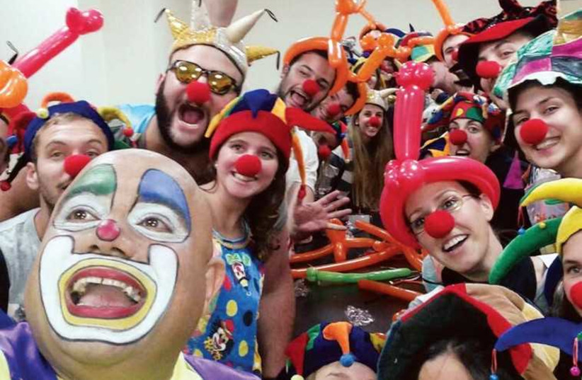 Taglit-Birthright participants with Itzik the clown at the Schneider Children’s Medical Center. (photo credit: TAGLIT-BIRTHRIGHT)