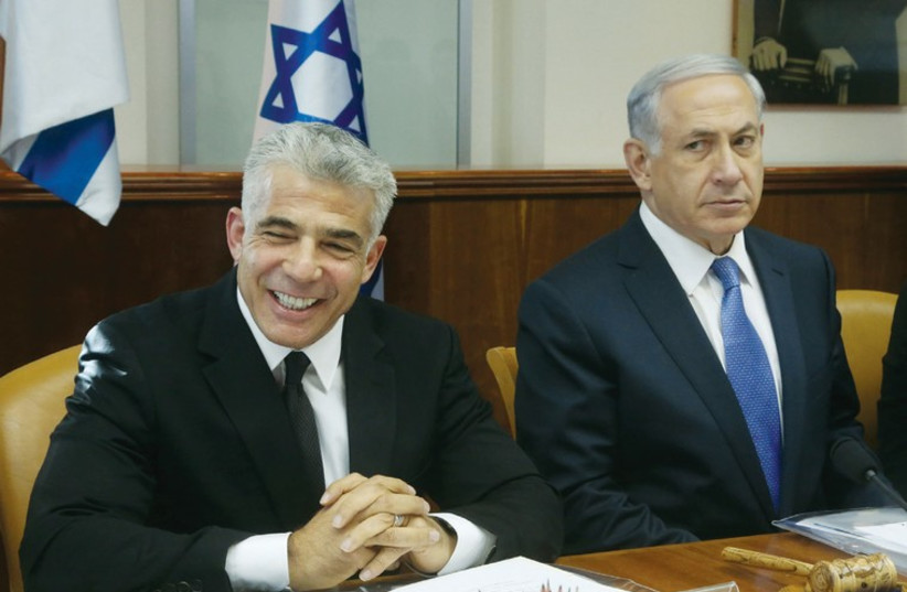Netanyahu and Lapid at a cabinet meeting in October 2014. (photo credit: MARC ISRAEL SELLEM/THE JERUSALEM POST)